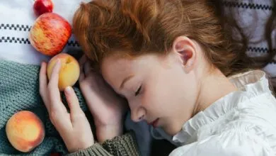 Serene image of a woman with closed eyes holding fruit. Captures tranquility and nature.