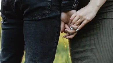 A couple holding hands outdoors, symbolizing connection and intimacy.