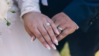 Close-up image of a couple's hands showing off diamond wedding rings, symbolizing love and marriage.