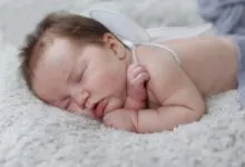 A peaceful baby with angel wings sleeping on a soft blanket, capturing innocence.