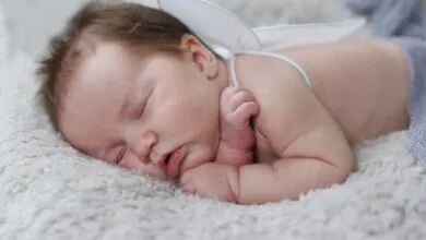A peaceful baby with angel wings sleeping on a soft blanket, capturing innocence.
