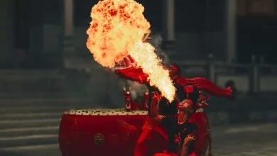 A skilled performer breathes fire in a captivating traditional show, creating a vibrant spectacle.