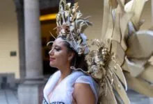 A woman wearing an elaborate golden costume with wings in Mexico City.