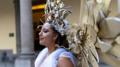 A woman wearing an elaborate golden costume with wings in Mexico City.