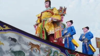 Colorful traditional parade float featuring zodiac symbols and ornate figures.