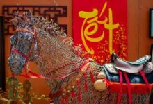 Colorful wire horse sculpture and Tet decorations create a festive scene outdoors.