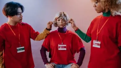 Volunteers share encouraging words by painting them on a face, promoting team spirit.