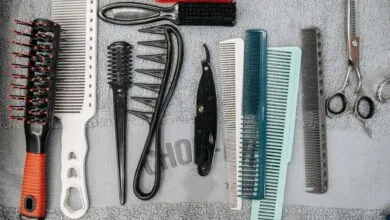 Flat lay of barber tools including combs, brushes, and scissors neatly arranged.