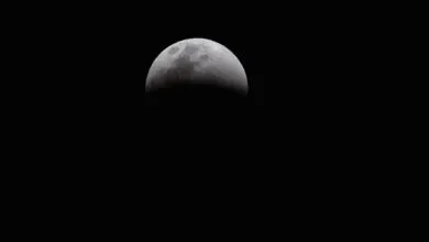 Dramatic view of a partial lunar eclipse showcasing the moon's shadowed surface against a dark sky.