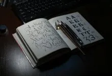 Open book showing Cyrillic calligraphy with quill pens on a desk, ideal for art and language themes.